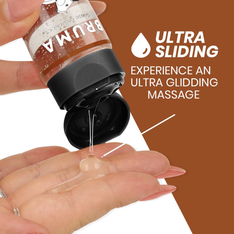 Een hand houdt een fles BRUMA massageolie vast terwijl een kleine hoeveelheid olie op de andere handpalm wordt gedruppeld.