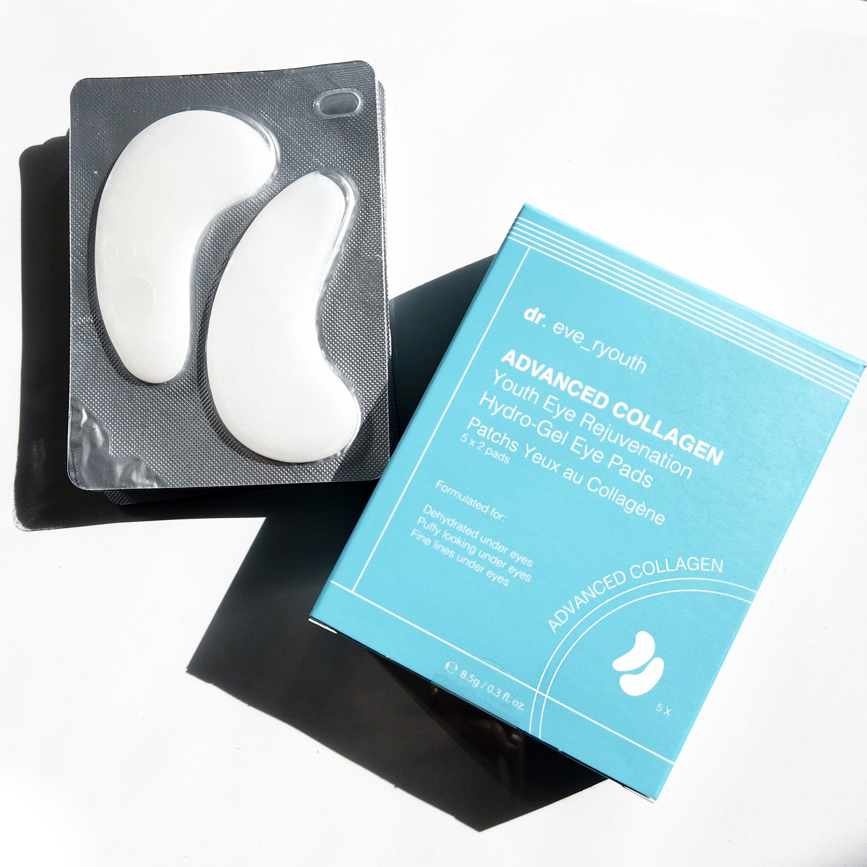 Deux patchs pour les yeux dans un emballage, à côté d'une boîte. Inscription : Dr. Eve_Ryouth, Advanced Collagen, Hydro-Gel Eye Pads.