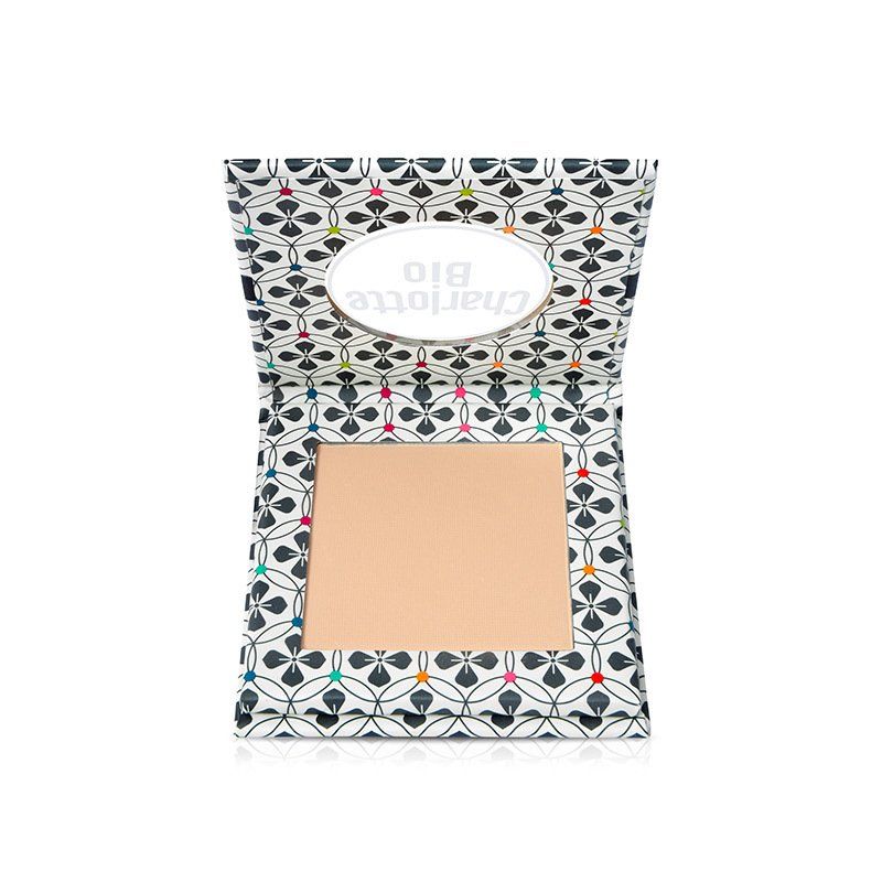 Poudre compacte dans un emballage ouvert. Charlotte Bio est écrit sur l'emballage. La poudre est beige clair.