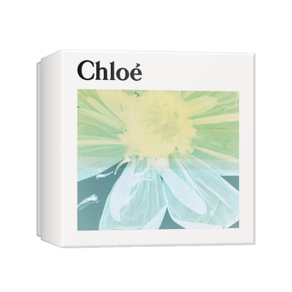 Vierkante geschenkverpakking met bloemenpatroon en merknaam. De doos is wit en toont een groot bloemenpatroon in groen- en blauwtinten.