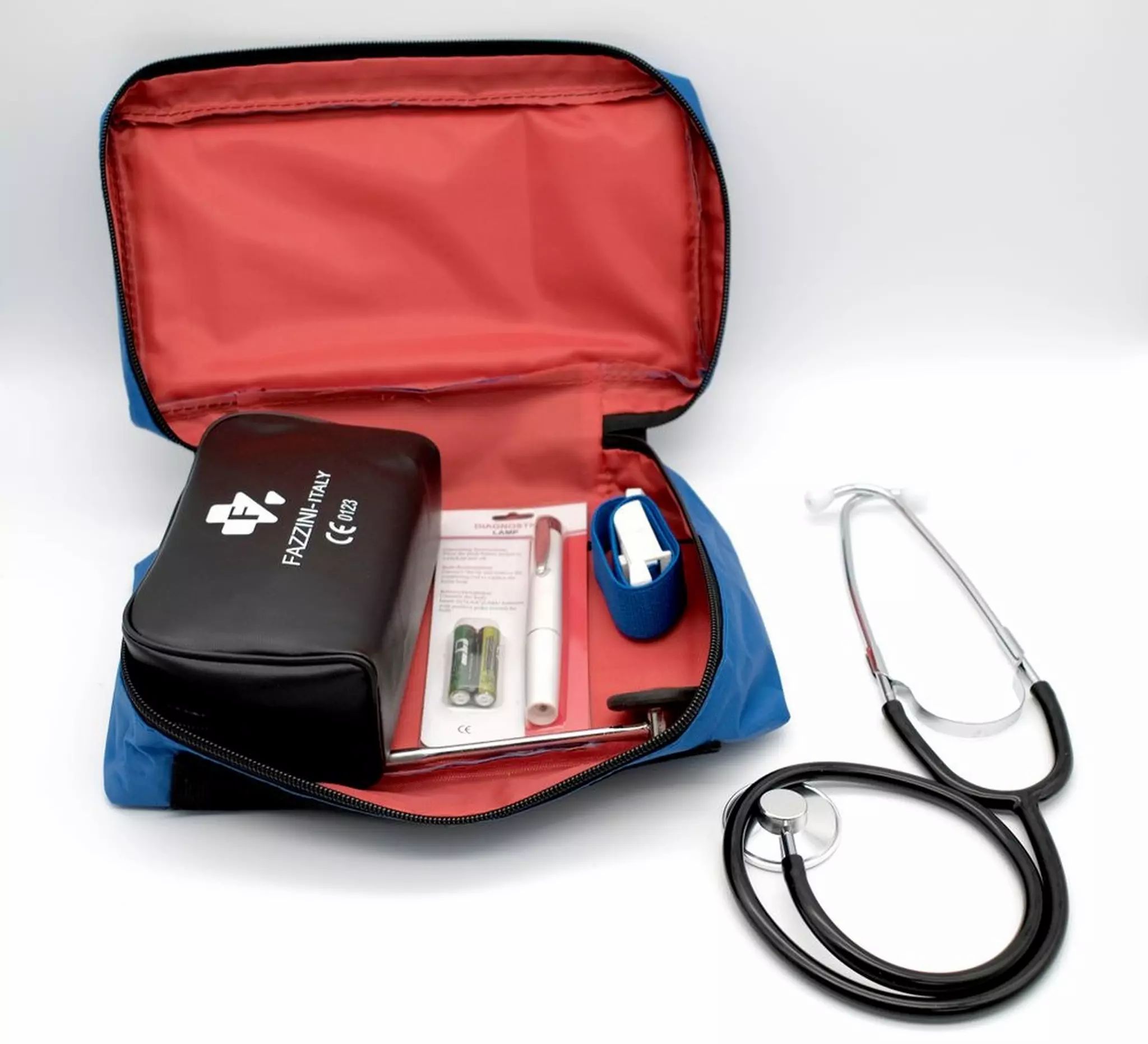 Set ouvert avec sac, stéthoscope, piles, marteau réflexe et lampe pupillaire. Intérieur rouge.