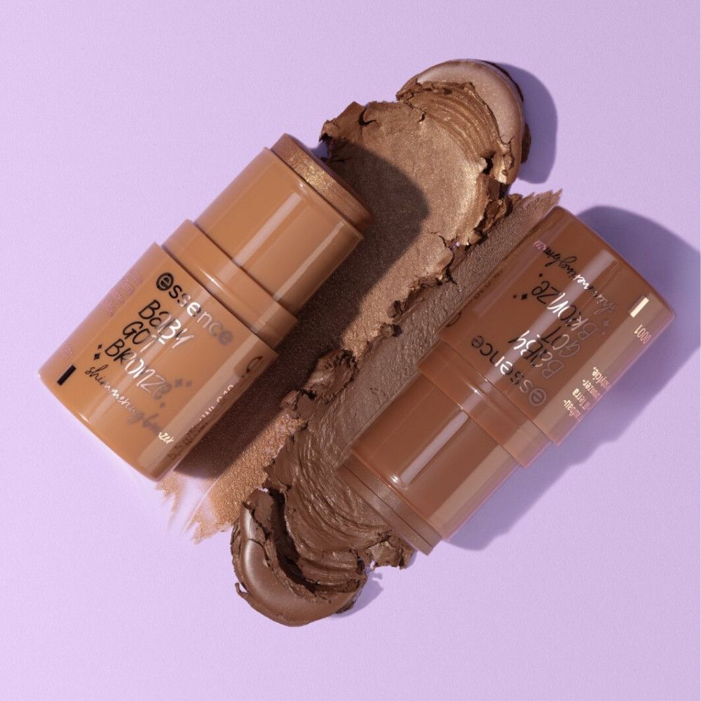 Twee bronzer sticks en een bronzer swirl op paarse achtergrond. Op de sticks staat "Essence Baby Got Bronze".