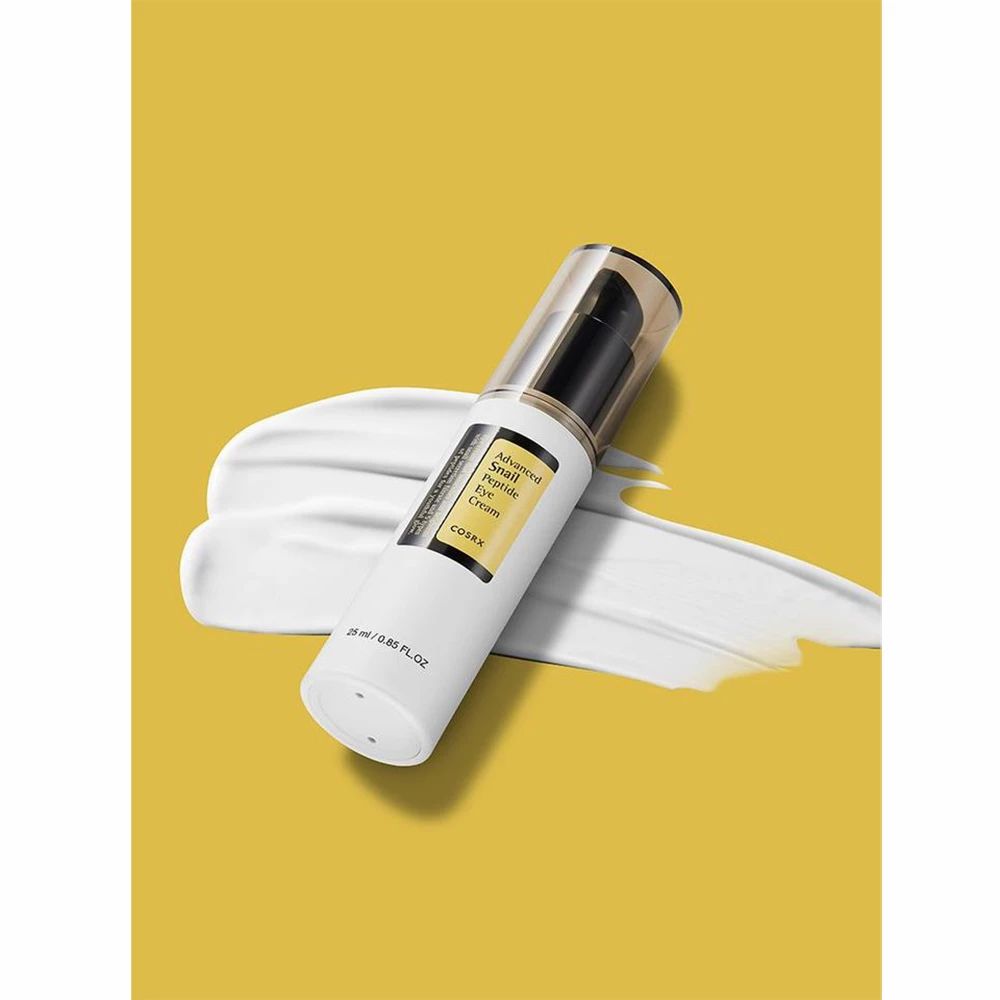 Fles op gele achtergrond met crème-uitstrijk. Zwarte pomp. Productnaam en merk zichtbaar.