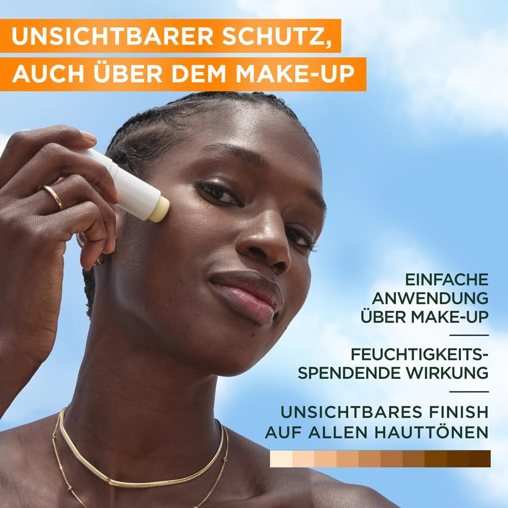 Une personne applique le stick solaire Garnier Ambre Solaire Super UV. Le bâton est blanc avec lettrage bleu et vert. Texte: Protection invisible.
