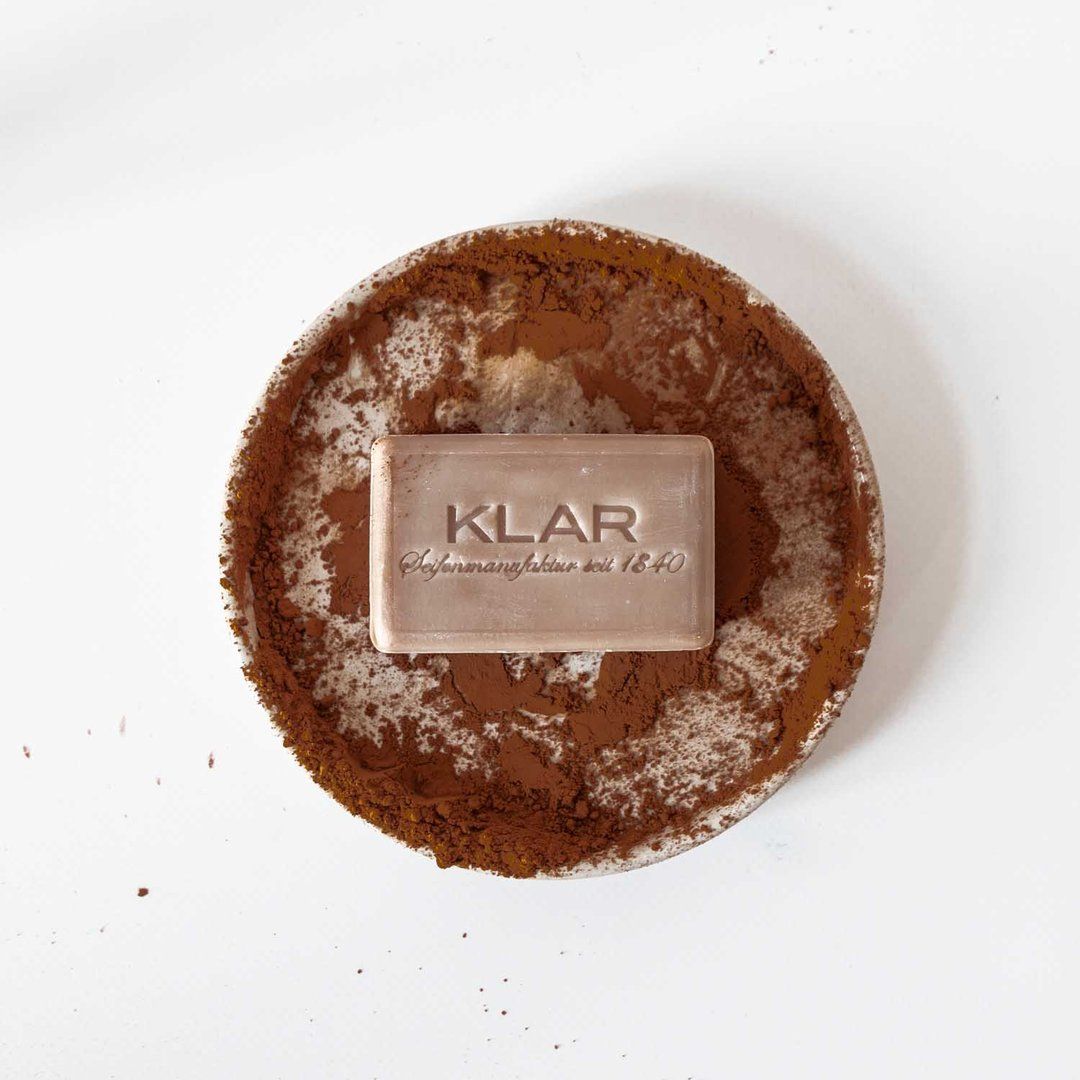 Rechthoekige zeep met KLAR-reliëf op een ondergrond van cacaopoeder. Zeep in een lichte bruintint.