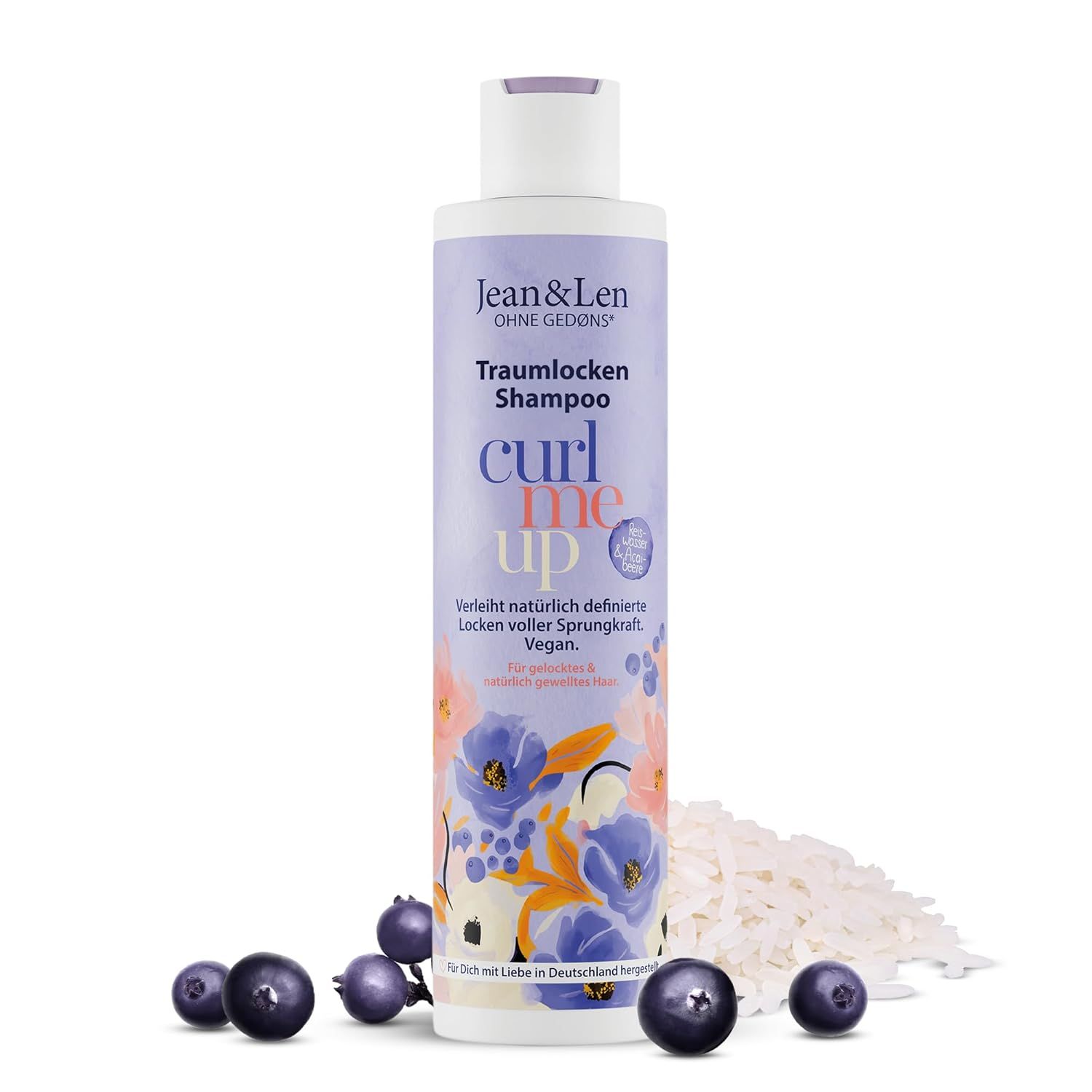 Shampoo fles met paarse dop. Opschrift: Jean & Len Traumlocken Shampoo. Met rijstwater & açaíbes. Rijst en bessen ernaast.