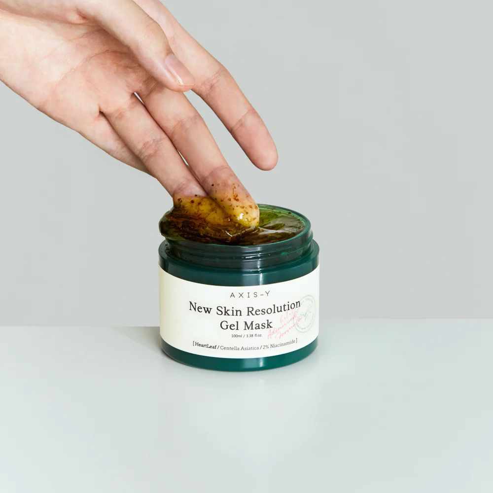 Un doigt prélève le masque gel Axis-Y New Skin Resolution d'un pot.