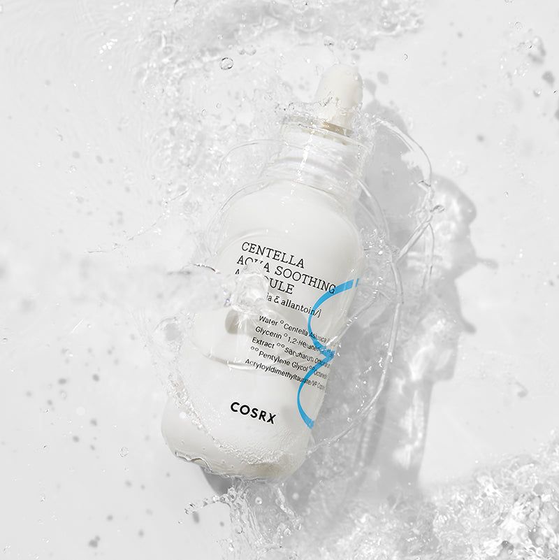 Witte fles met blauw etiket in water. Opschrift: Centella Aqua Soothing Ampoule. Merk: COSRX.