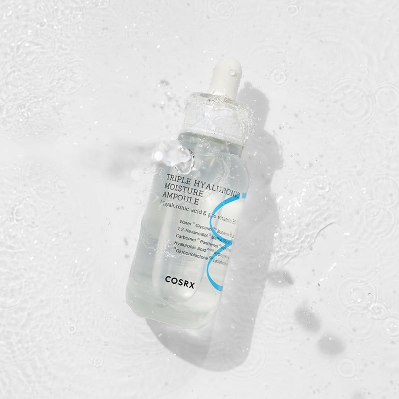 Ampul met pipet in water. Opschrift: Triple Hyaluronic Moisture Ampoule, COSRX. Water spettert.