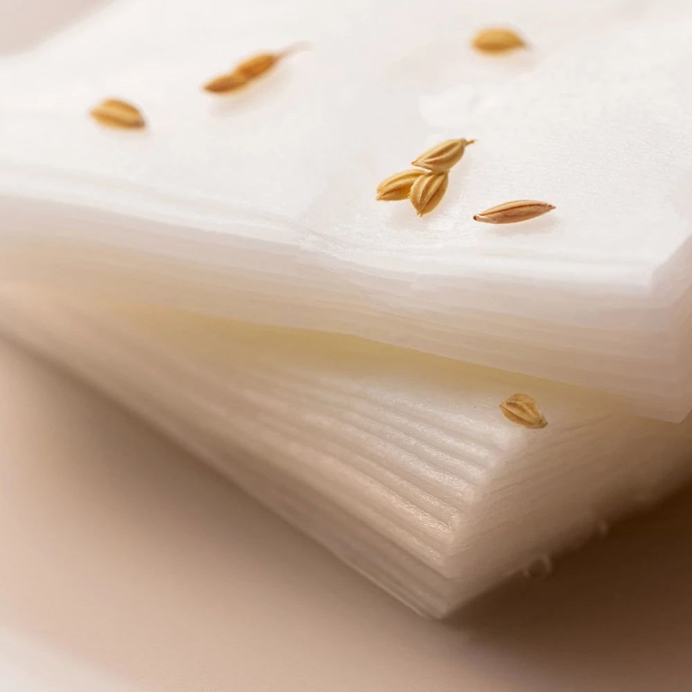 Pile de masques faciaux blancs. Quelques grains de riz sur les masques. Gros plan.
