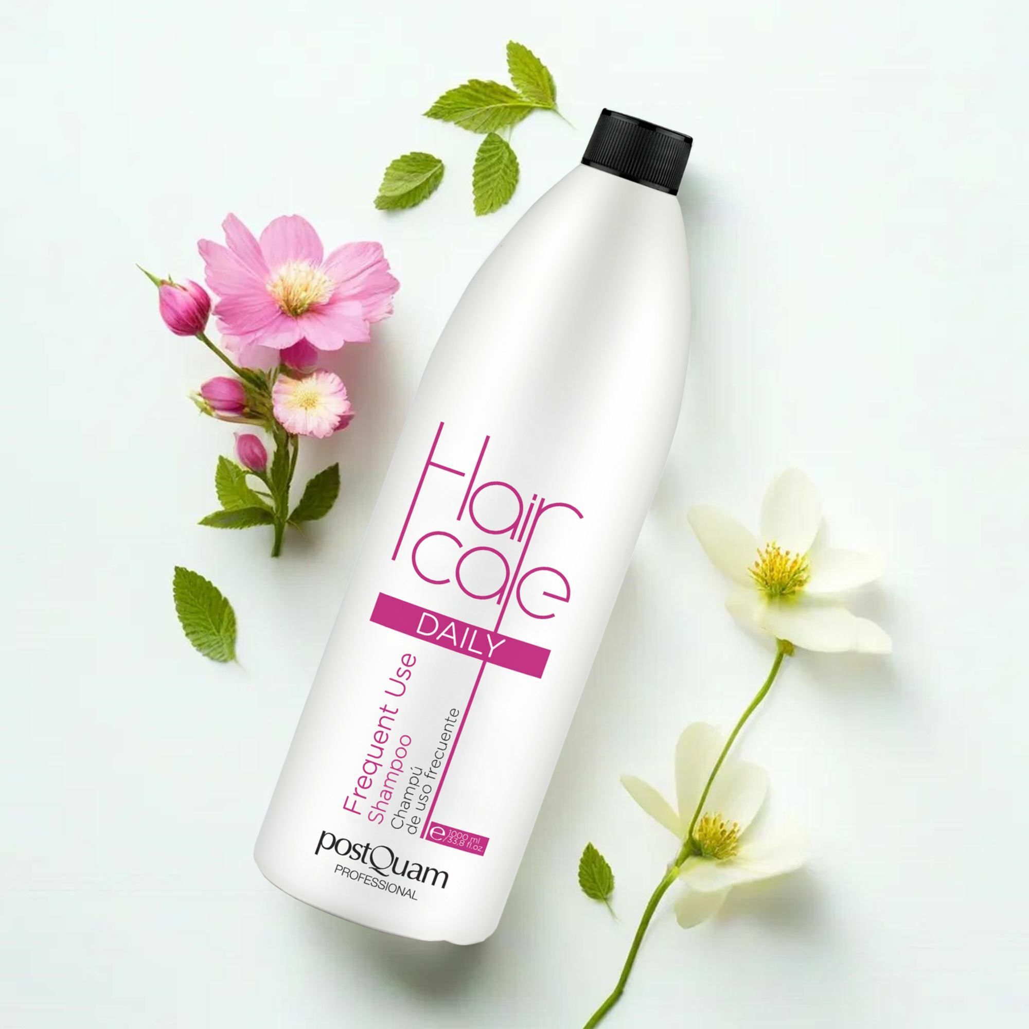 Witte shampoo fles met zwarte dop. Opschrift 'Hair care DAILY' en 'PostQuam'. Decoratie met bloemen en bladeren.