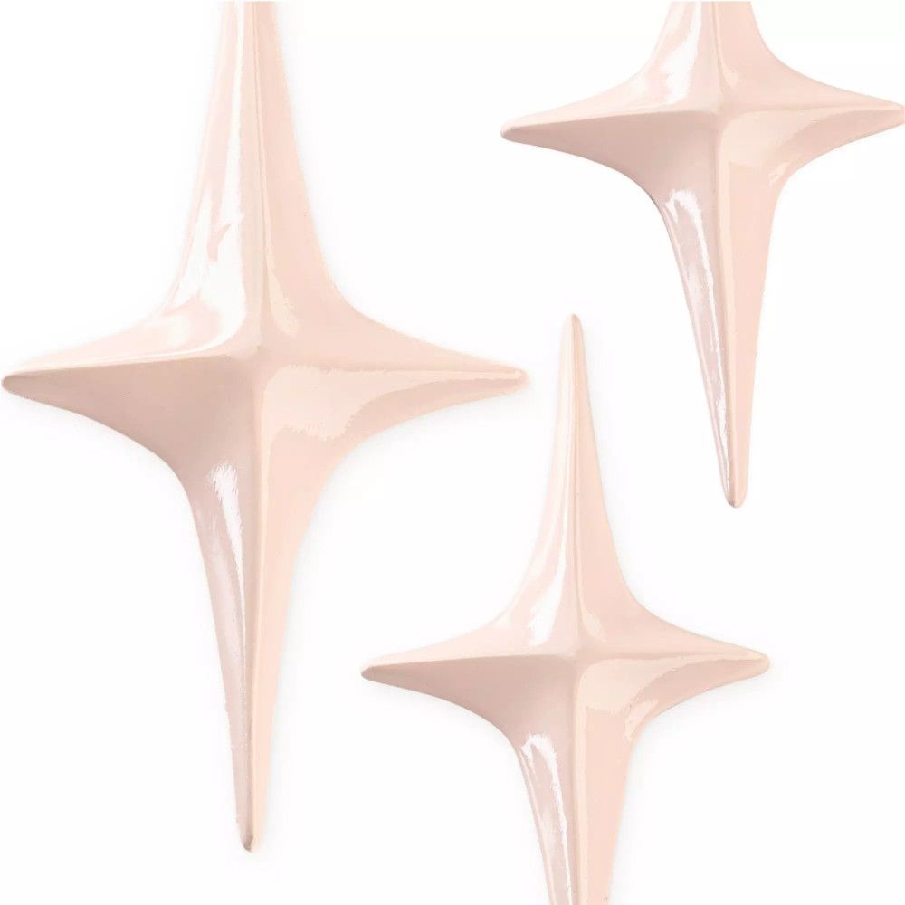 Trois décorations en forme d'étoile rose clair. Surface brillante.