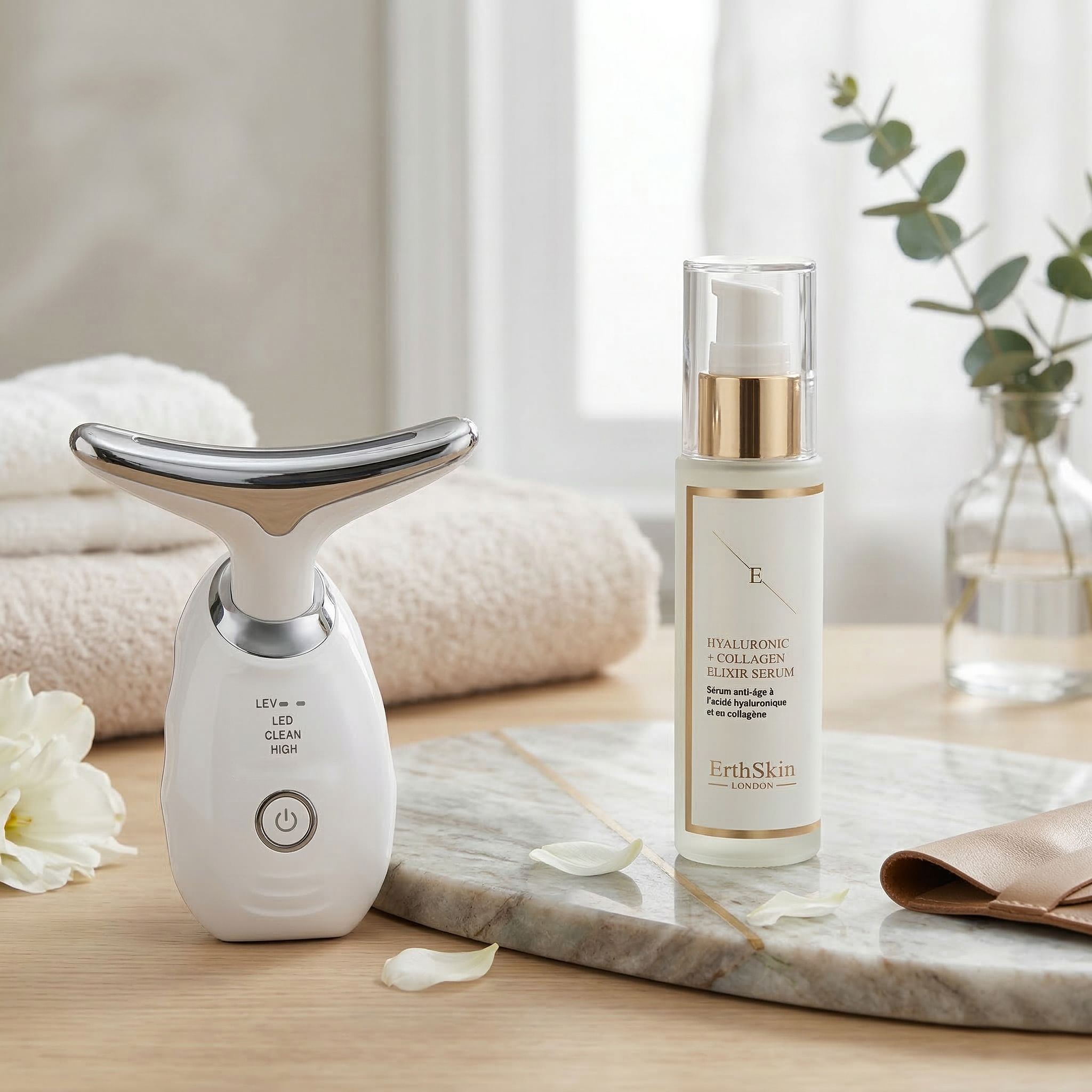 Erth Skin London nek LED-massager en hyaluronzuur collageen elixer serum op marmeren plaat.