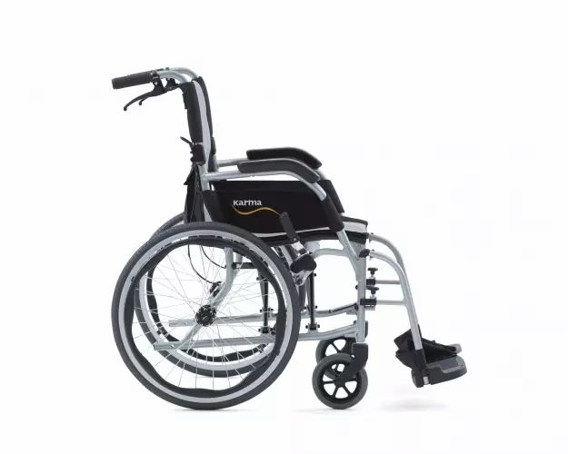 Vue latérale d'un fauteuil roulant léger avec cadre argenté, accoudoirs noirs et grandes roues.