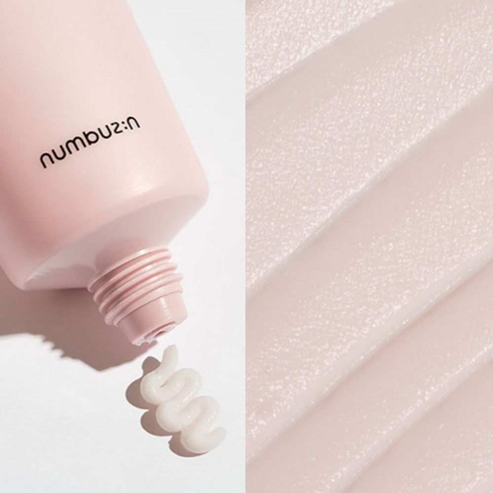 Roze crèmetube. Crème wordt eruit geperst. Merk: numbuz:n. Crèmetextuur.