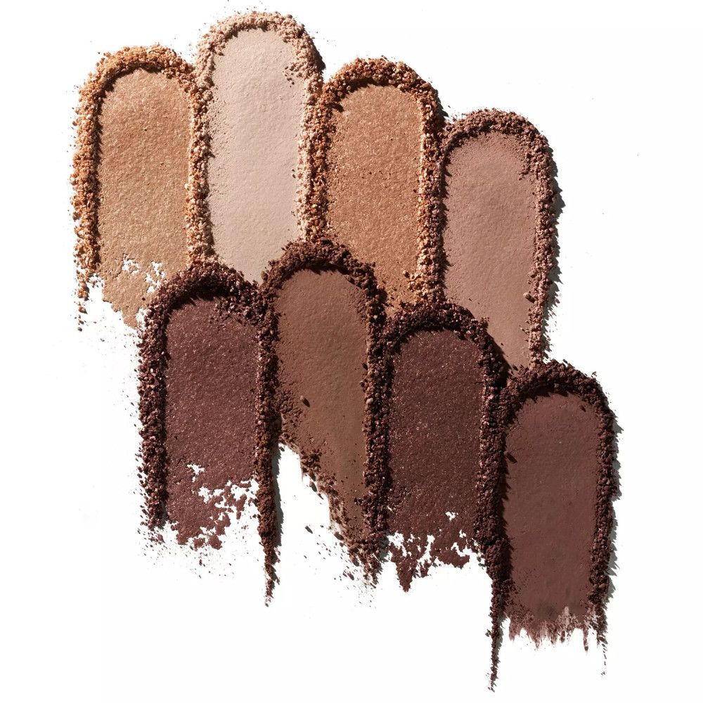 Acht kleurstalen van oogschaduw in verschillende nude tinten op witte achtergrond. De stalen zijn langwerpig en licht uitgesmeerd.