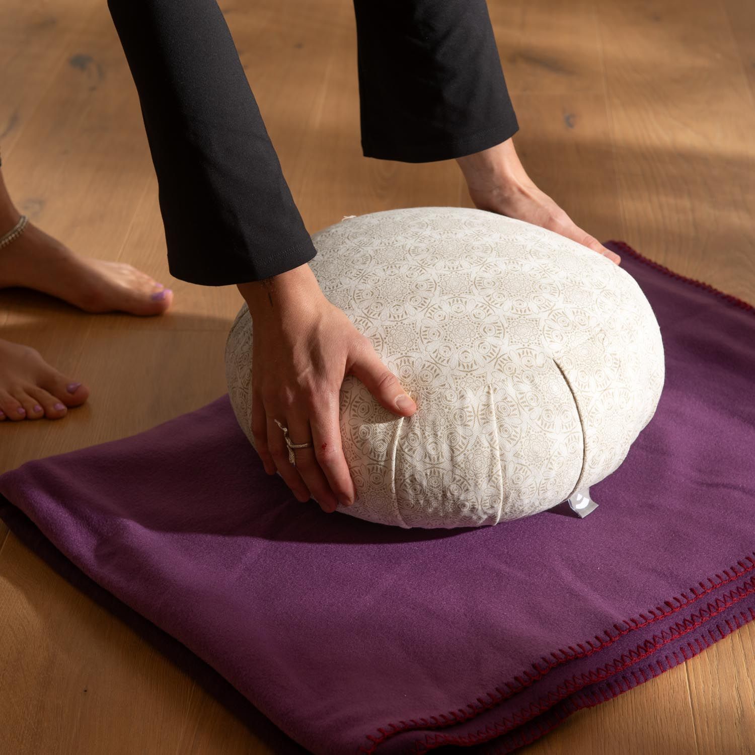 Coussin de méditation Bodhi Zafu avec motif sur tapis violet.