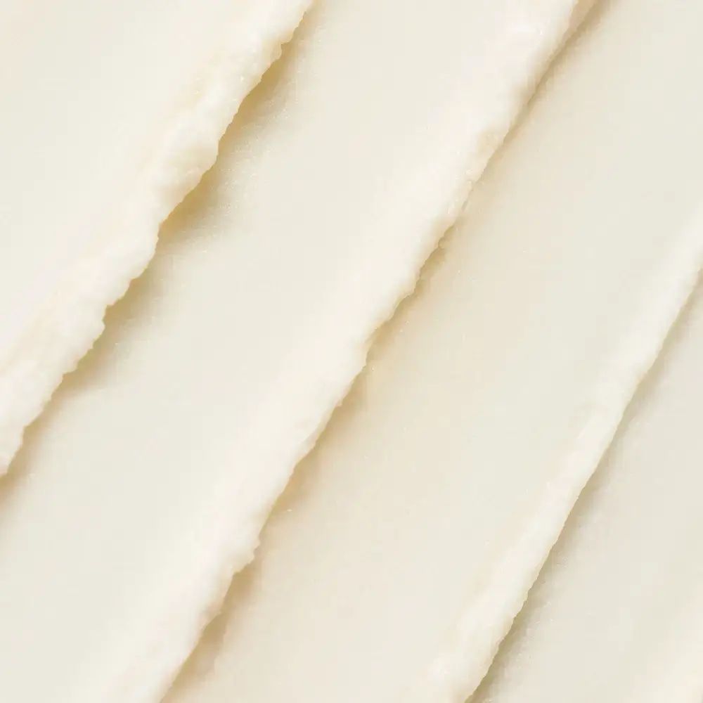 Gros plan sur la texture crémeuse et blanche d'une crème solaire. Rayures diagonales. Texture inégale.