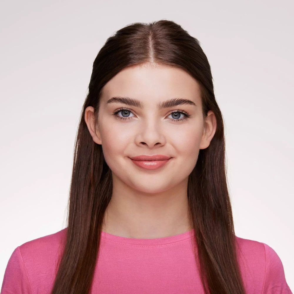 Portret van een jonge vrouw met bruin haar en een roze top. Ze glimlacht.