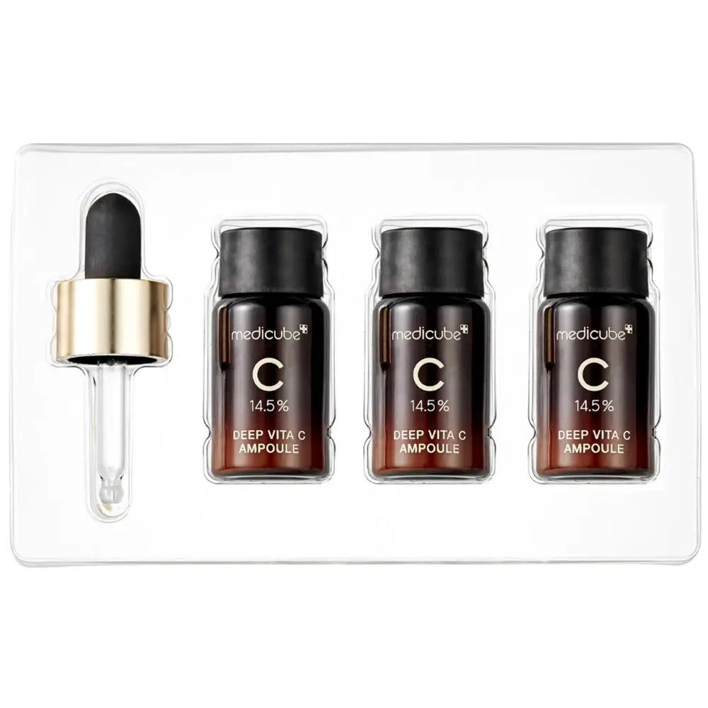 Emballage avec trois flacons de sérum et une pipette. Flacons avec bouchons noirs, bagues dorées. Récipient transparent.