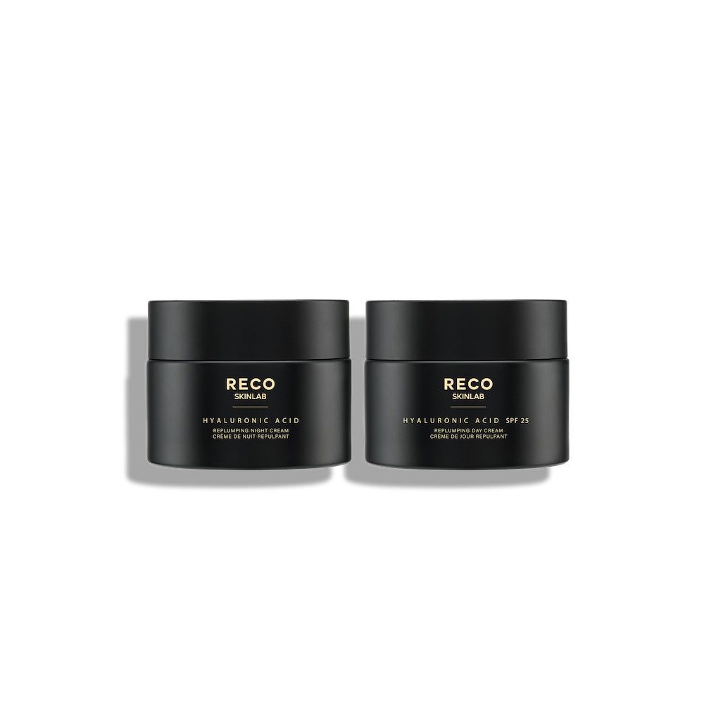Twee zwarte potten met deksels. Opschrift RECO SKINLAB, hyaluronzuur, dag- en nachtcrème. Beide staan naast elkaar.
