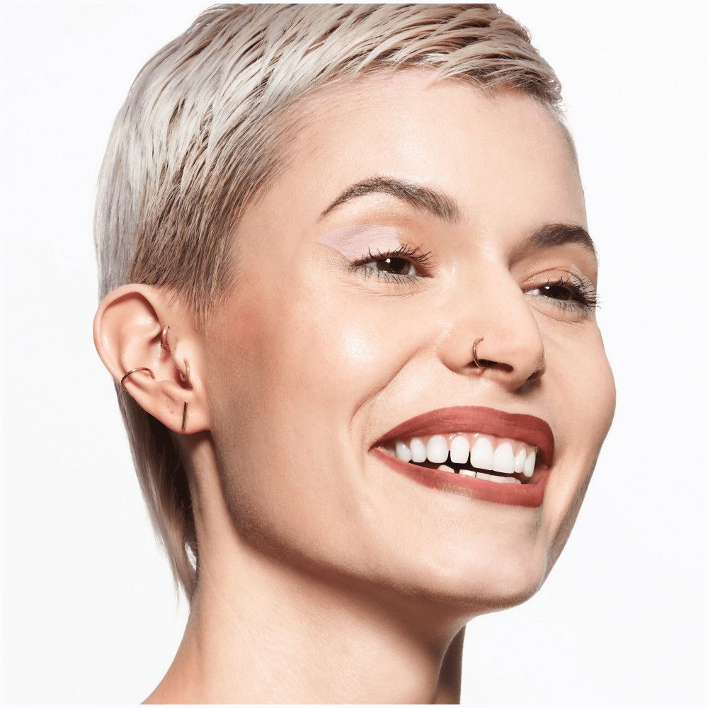 Portret van een vrouw met lippenstift. Ze glimlacht. Zichtbare lipkleur.