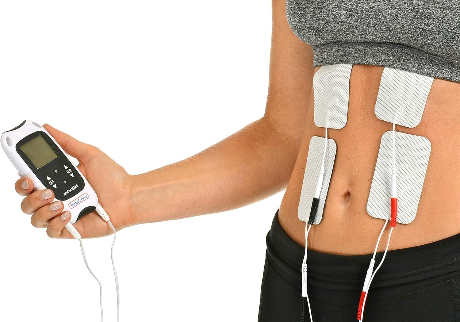 Personne tenant un appareil TensCare Perfect EMS. Coussinets d'électrodes fixés sur l'abdomen.