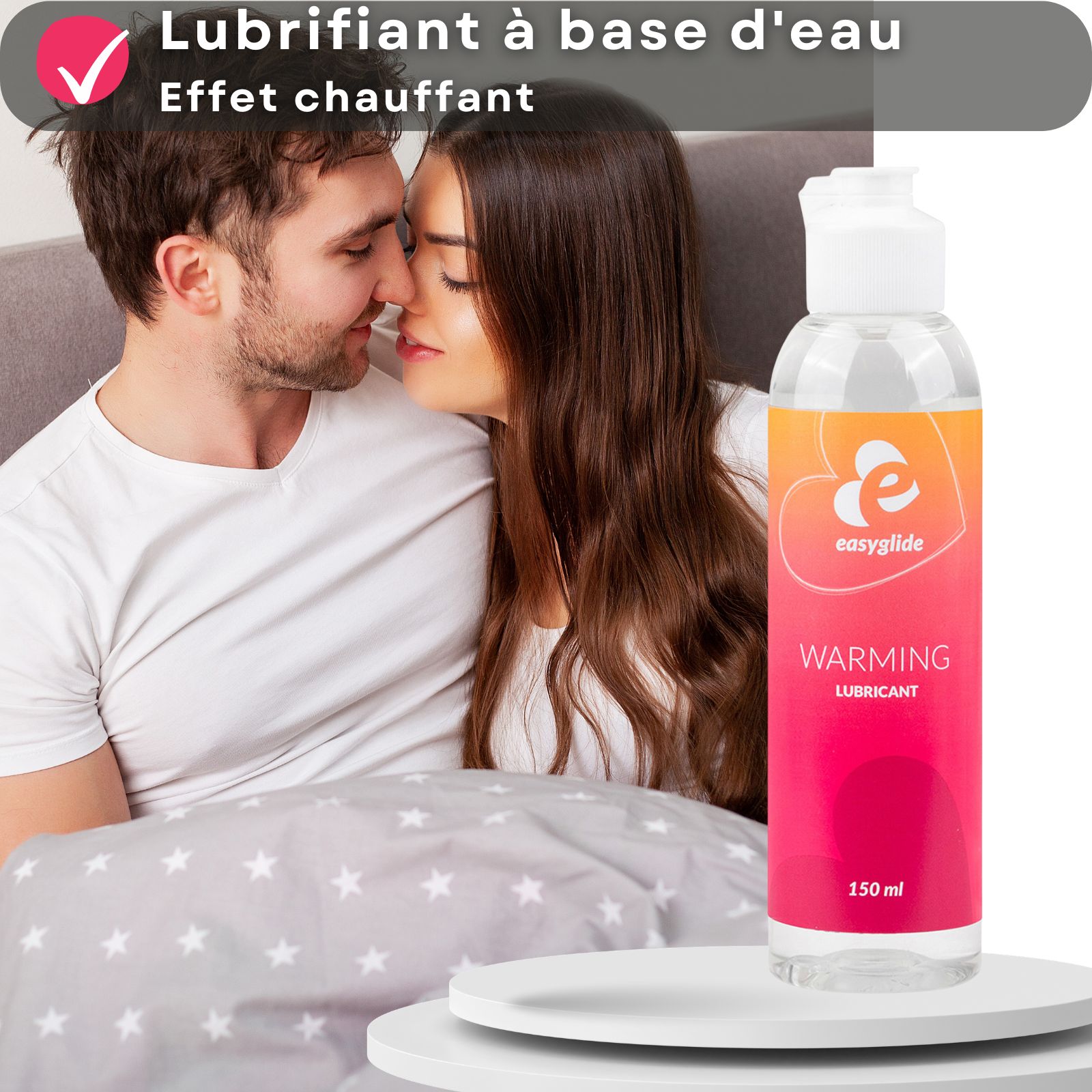 Flacon de gel lubrifiant. Dégradé orange/rose. Inscription : Warming Lubricant. 150 ml. Couple en arrière-plan.