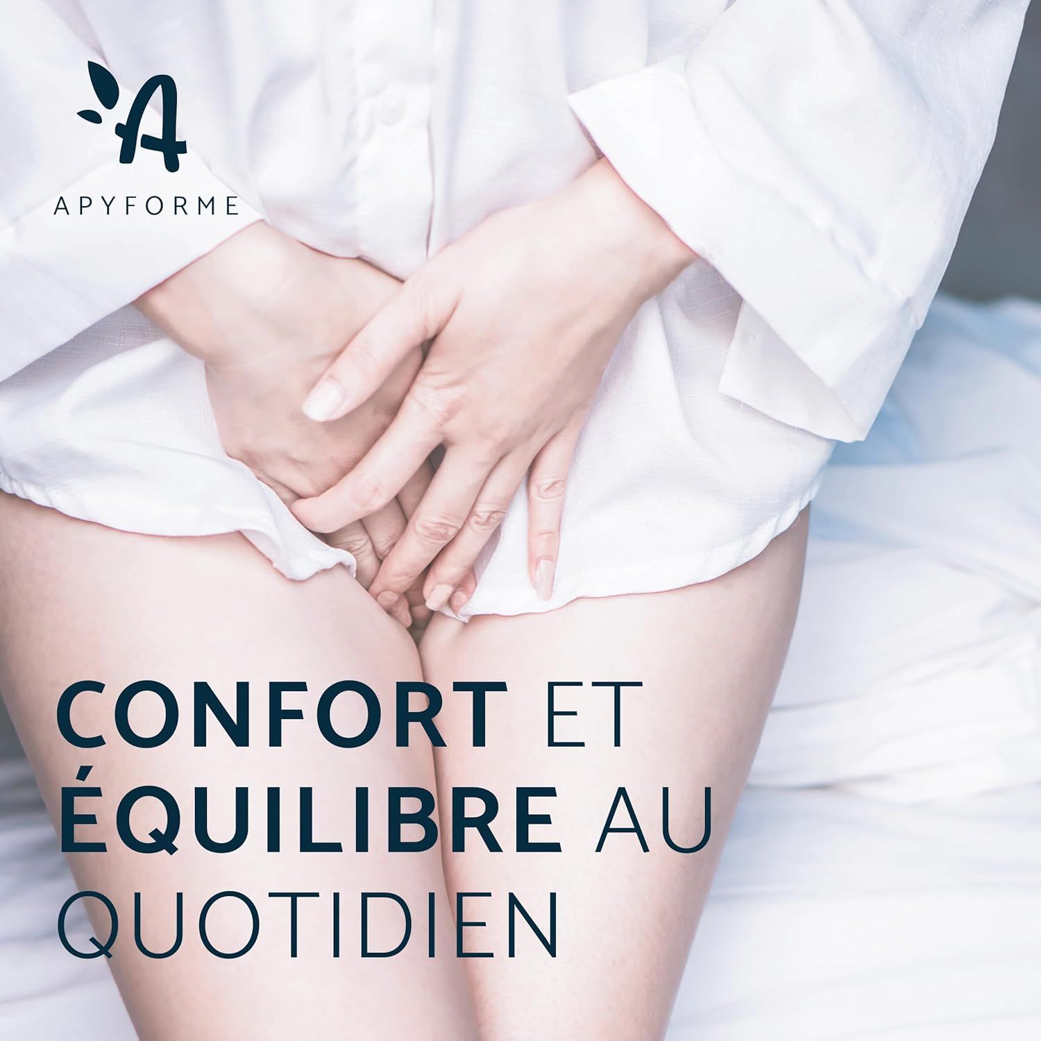 Femme en chemise blanche, mains devant le bas-ventre, logo APYFORME en haut à gauche.