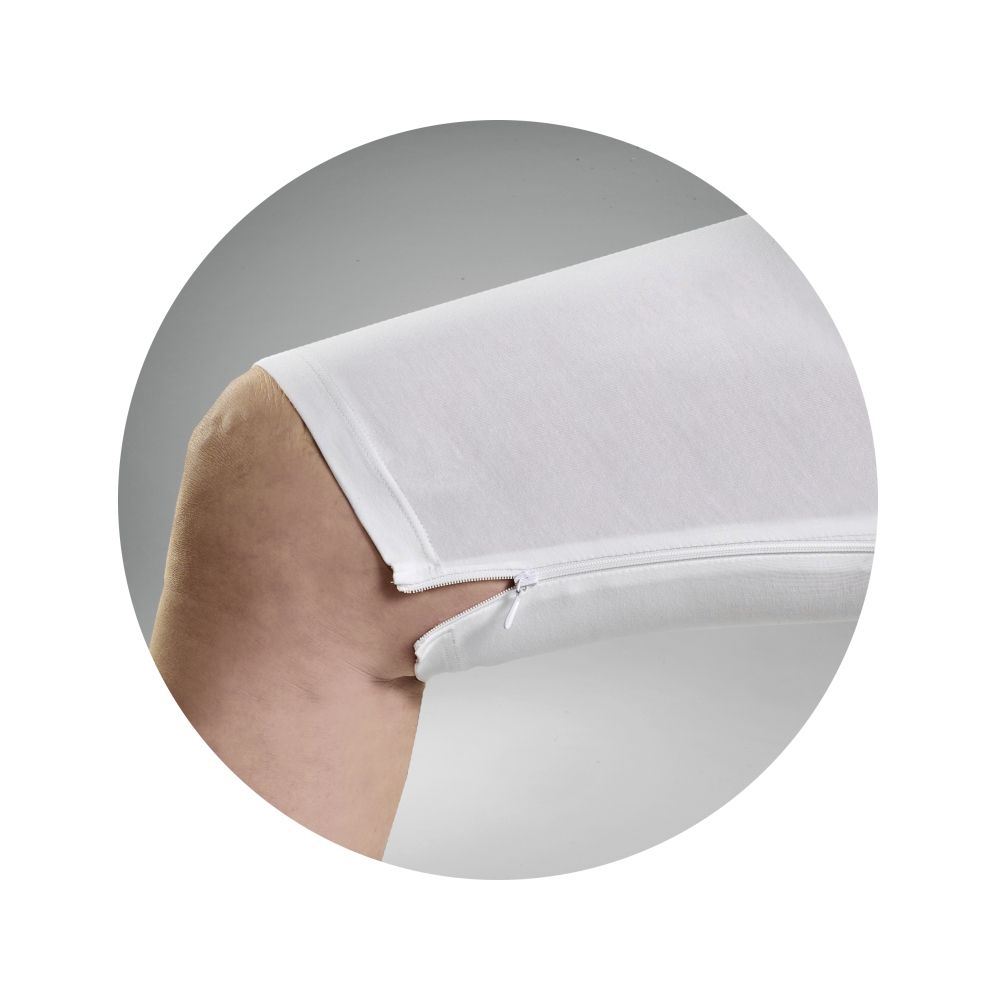 Close-up van een witte verzorgingsbody met een rits op de arm. De rits is gedeeltelijk geopend.