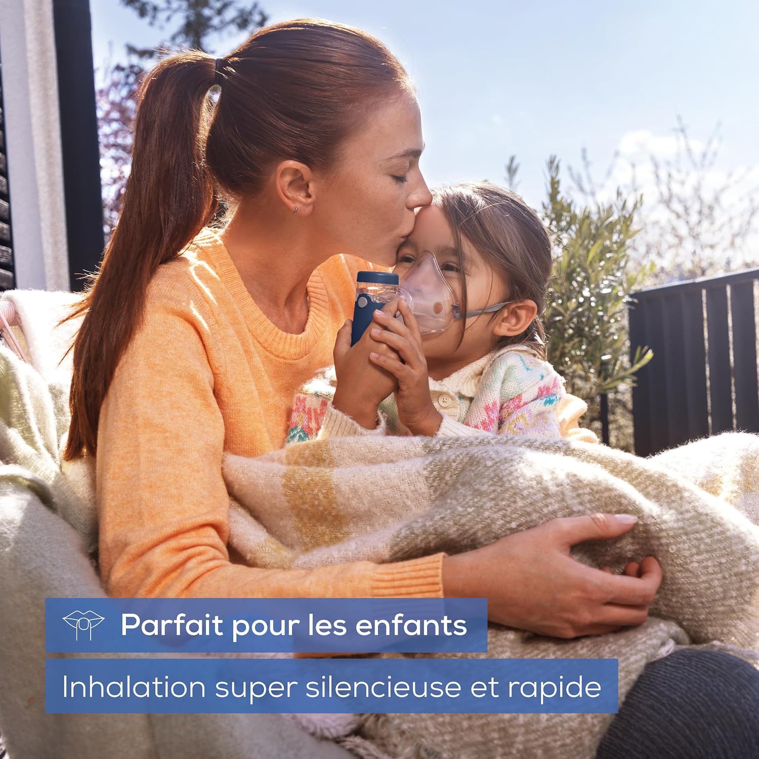 Un appareil de nébulisation portable tenu par une femme, administré à un enfant portant un masque.