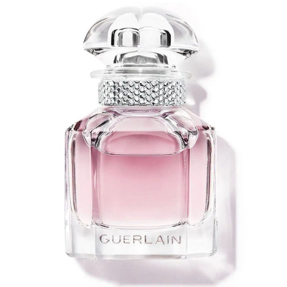 Roze parfumfles met transparante dop en strass. Guerlain-logo duidelijk zichtbaar.