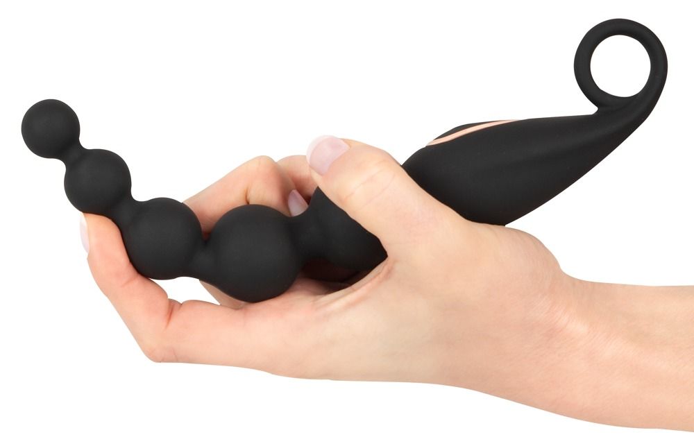 Zwarte anale kralen met vibratie, vastgehouden in een hand, focus op de bolvormige vorm en de ring.