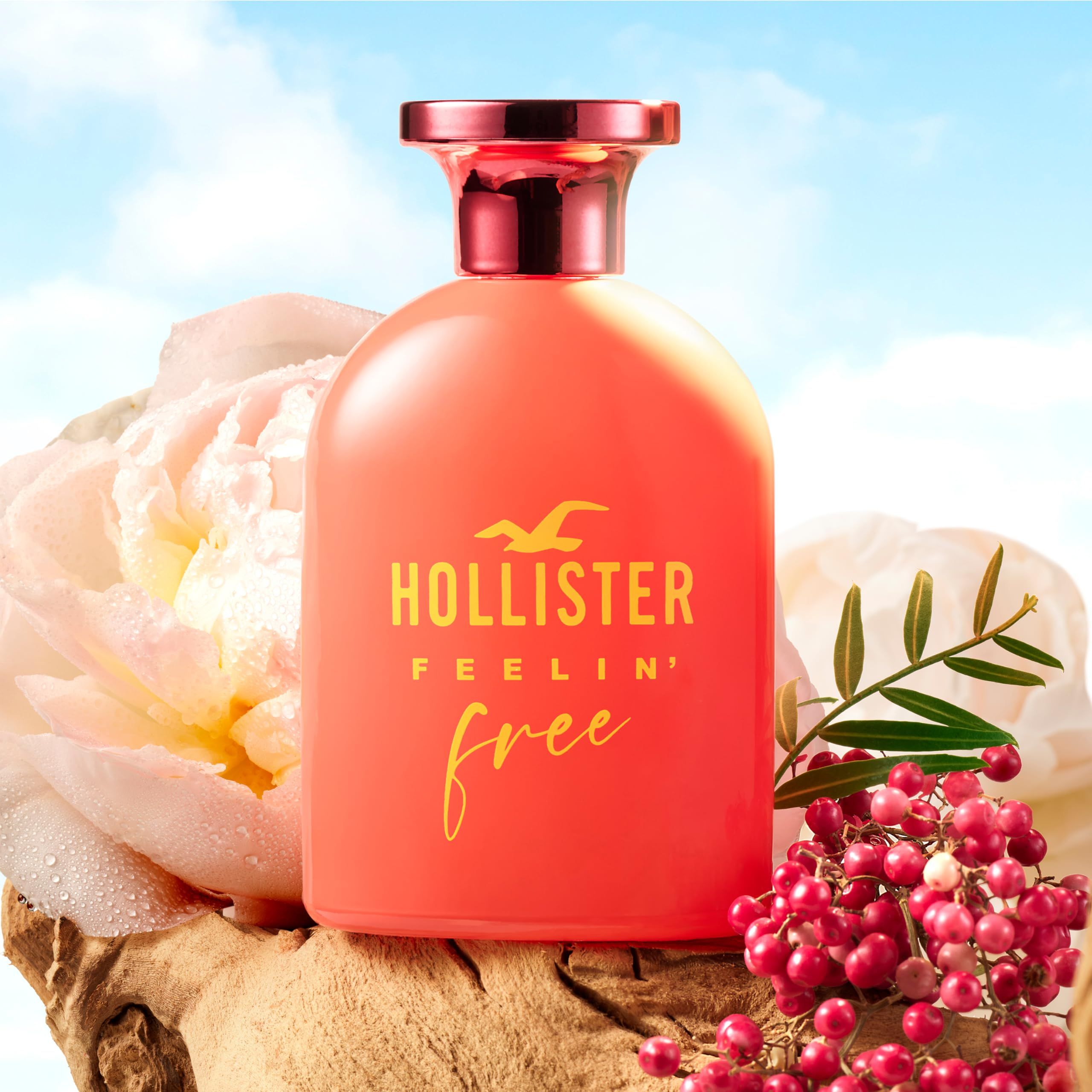 Rode fles met gele tekst. Opschrift: Hollister Feelin' Free. Roze dop. Achtergrond: bloemen.