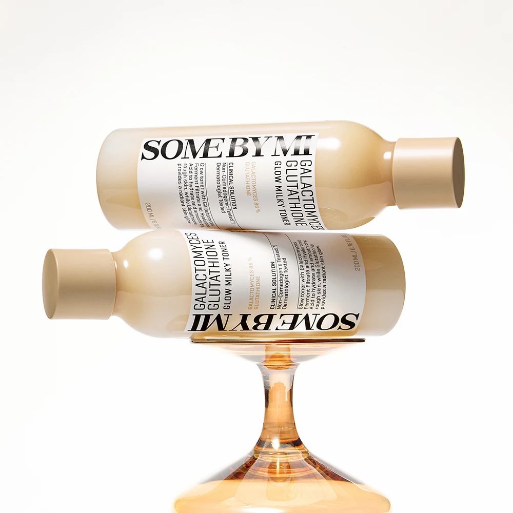 Twee flessen SOME BY MI, Galactomyces Glutathione Glow Milky Toner, op een glas.