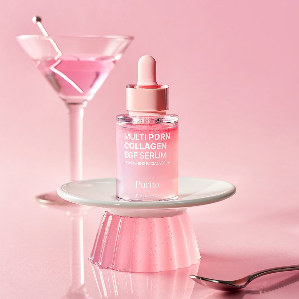 PURITO serumfles op een schoteltje naast een martiniglas met roze vloeistof.