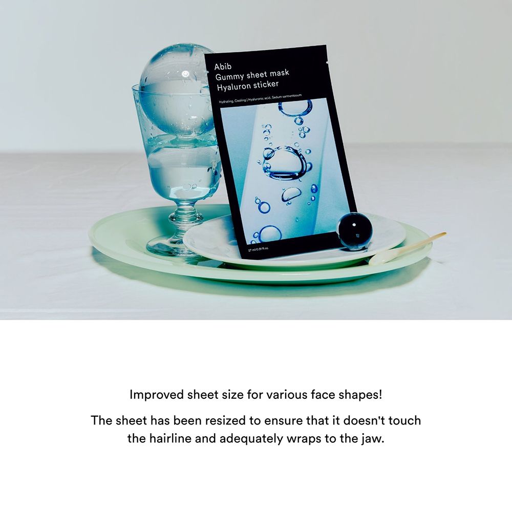 Emballage noir avec nom du produit et ingrédients. Sur une assiette, à côté d'un verre et d'une boule.