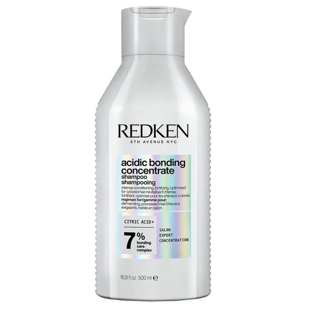 Flacon de shampooing Redken blanc. Étiquette avec nom et ingrédients. 500 ml.