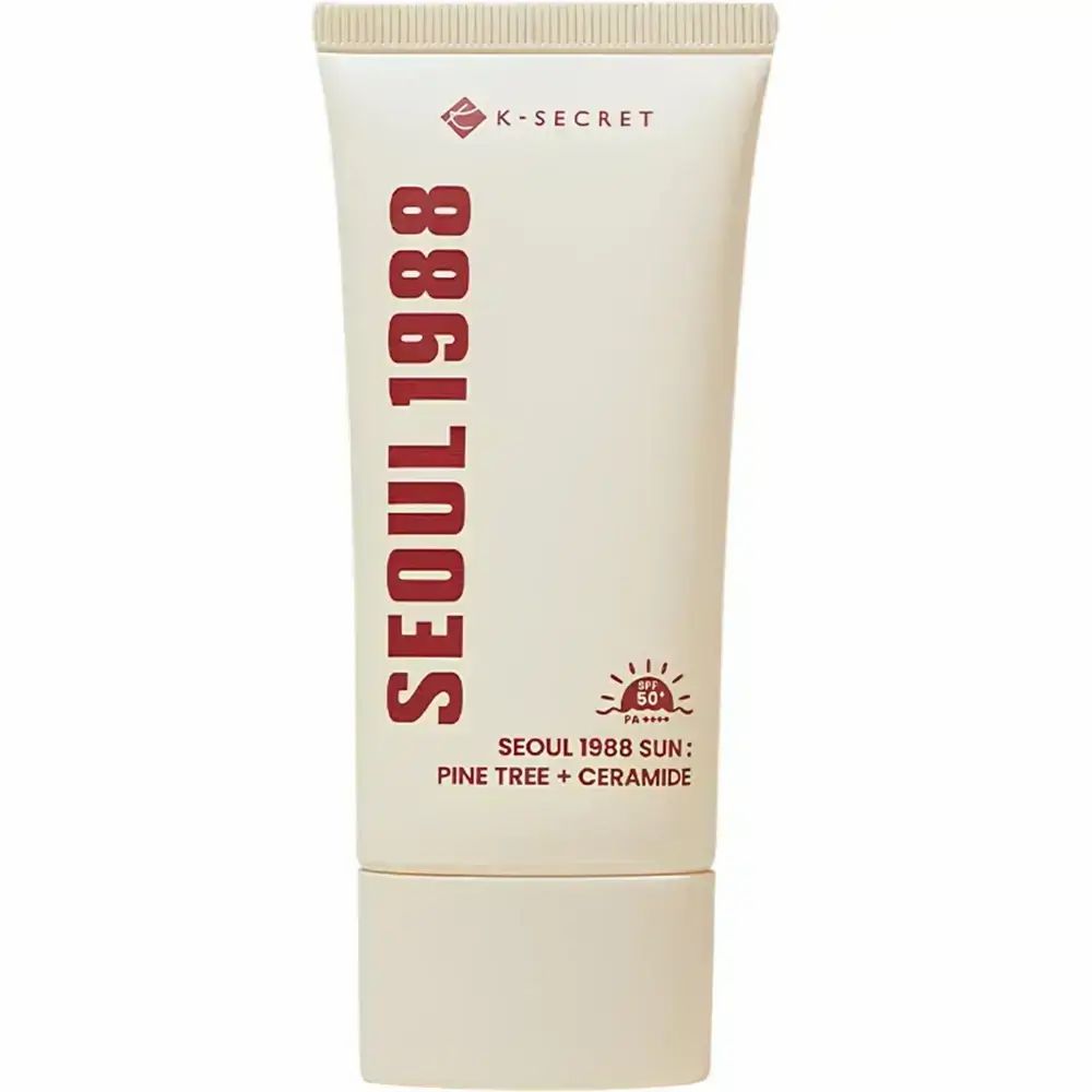 Tube de crème avec texte rouge : SEOUL 1988, SUN: PINE TREE + CERAMIDE. Marque K-SECRET. SPF 50.