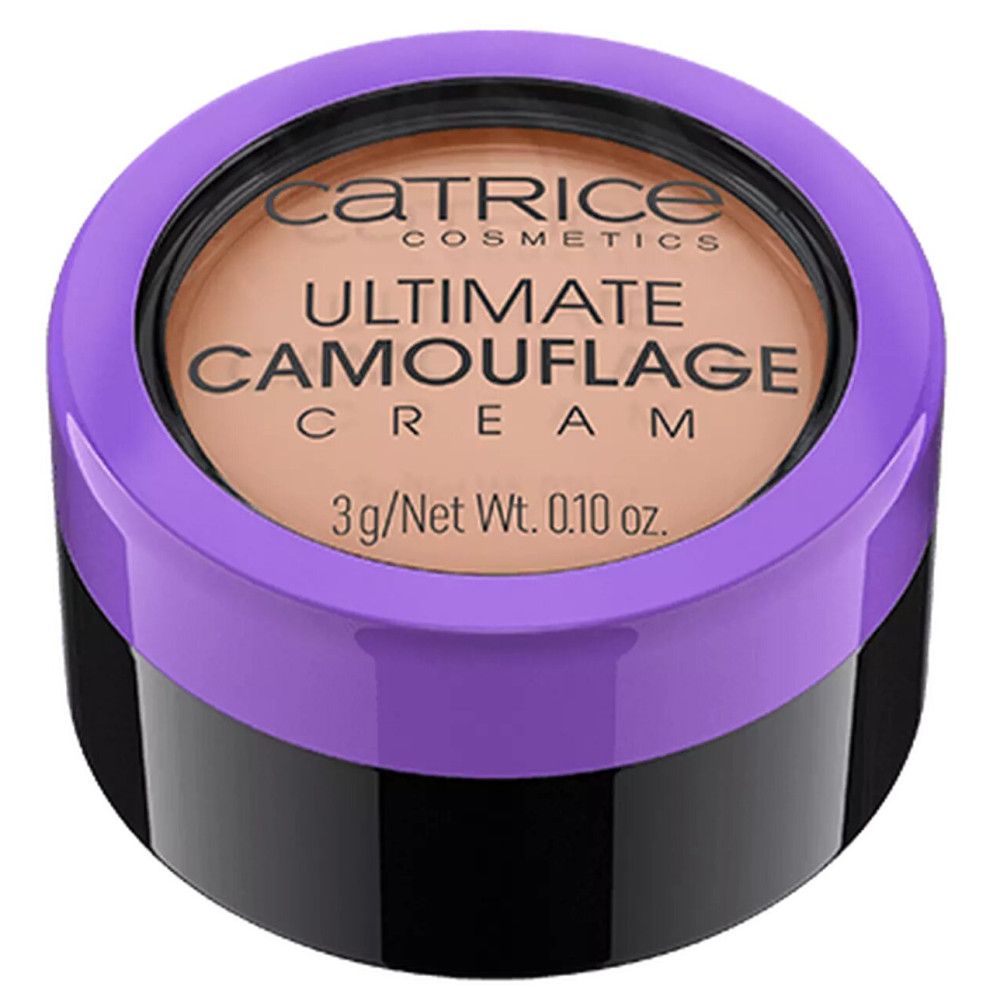 Crème camouflage beige dans un pot noir avec un couvercle violet. "ULTIMATE CAMOUFLAGE CREAM" est écrit sur le couvercle.