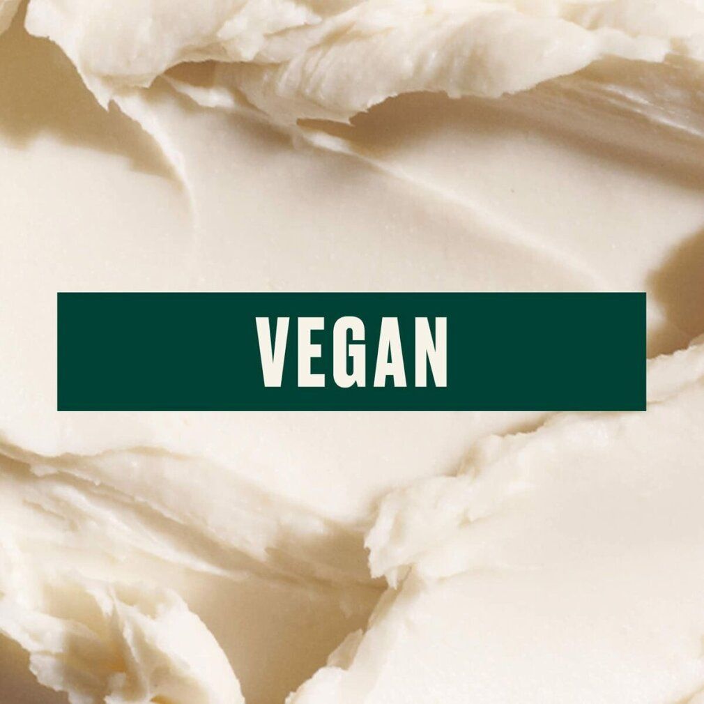 Gros plan sur du beurre corporel crémeux. Autocollant vert avec l'inscription : VEGAN.