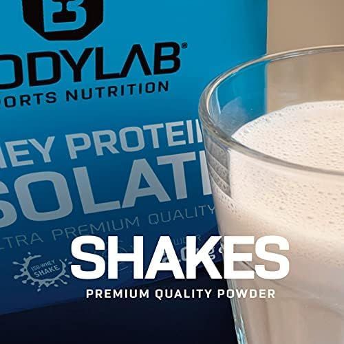 Verre de shake devant un fond bleu avec Bodylab Whey Protein Isolate. Texte : Shakes, Premium Quality Powder.