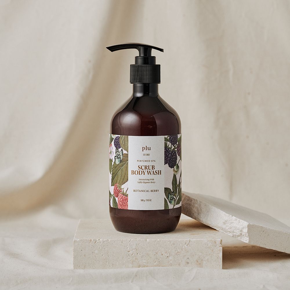 Flacon brun avec pompe noire. Étiquette avec nom du produit et illustrations florales. Placé sur un socle.