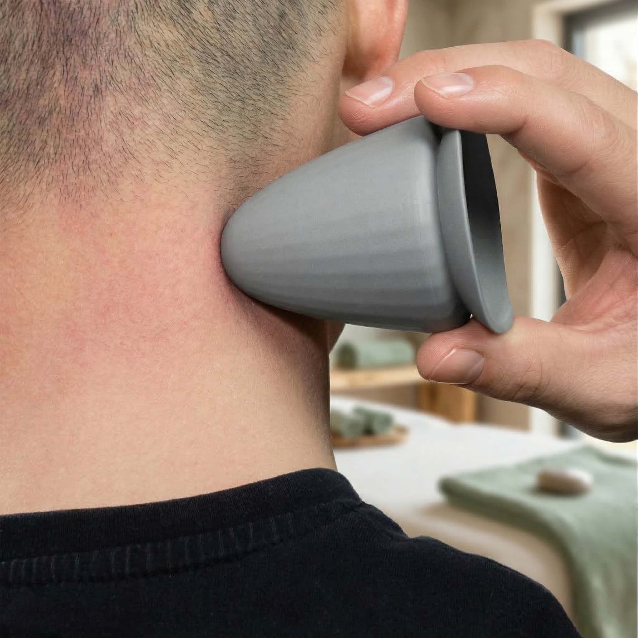 Grijs, kegelvormig product wordt op de nek van een persoon gebruikt. Hand houdt het product vast.