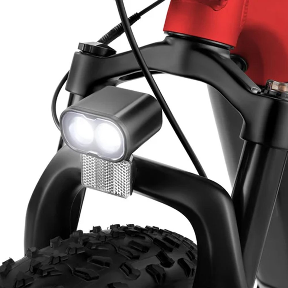 Gros plan de la fourche avant noire d'un vélo électrique. Double phare, réflecteur, pneu noir.