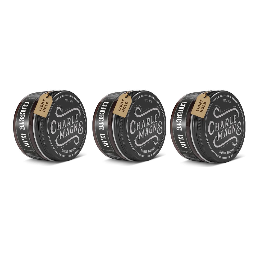 Drie ronde, zwarte blikken met deksels. Op elk blik staat "Concrete Clay" en "CHARLE MAGNE &" en een label met "LIGHT HOLD".