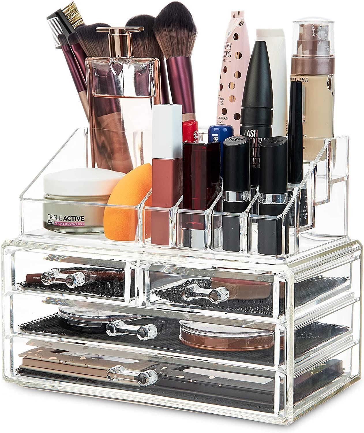 Transparante acryl make-up organizer met meerdere vakken en lade, gevuld met make-up en kwasten.
