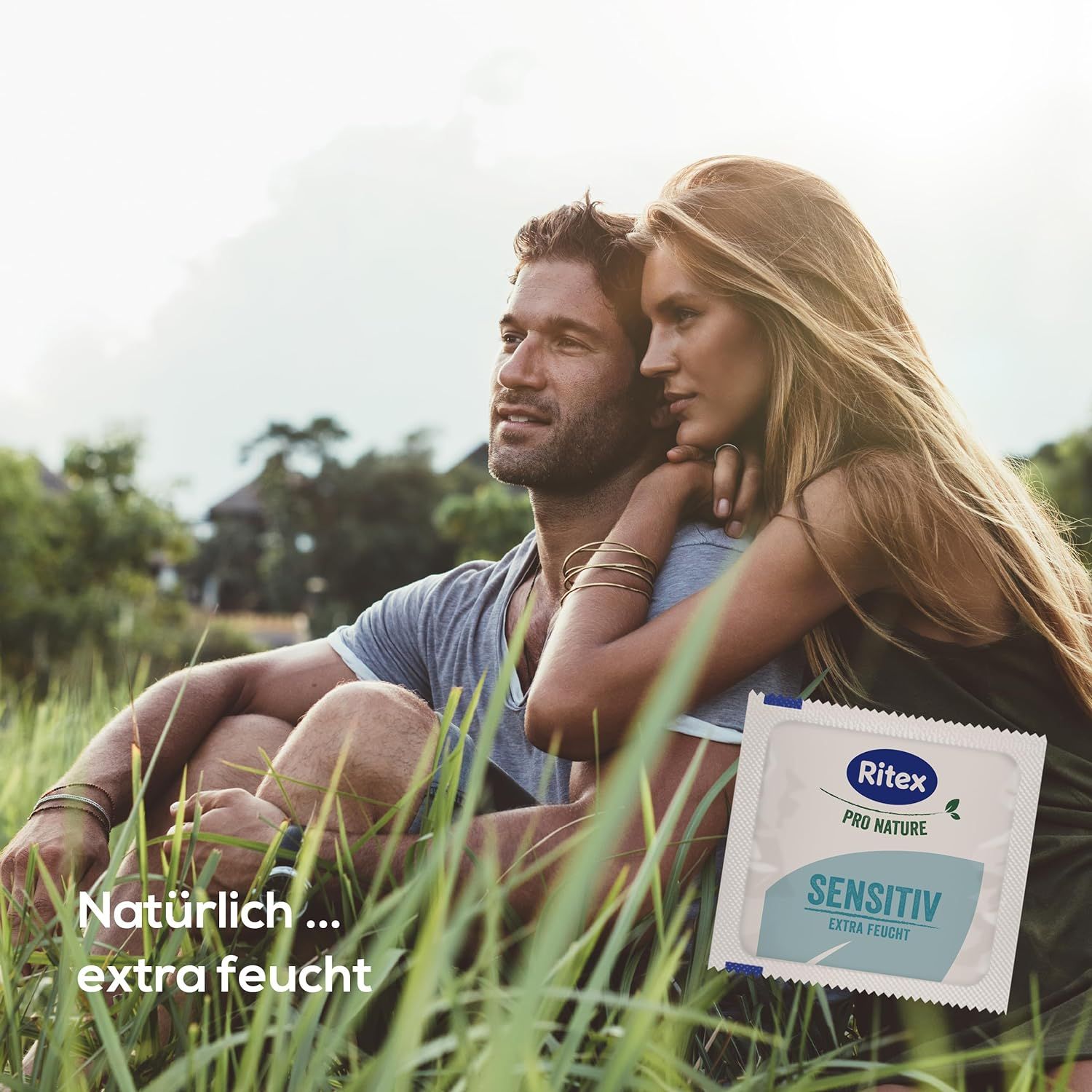 Couple assis dans l'herbe. Paquet de préservatifs avec Ritex Pro Nature Sensitiv extra feucht. Texte : Naturellement... extra humide.