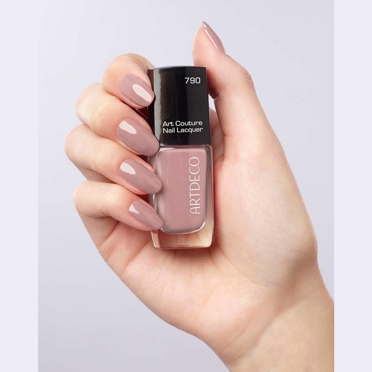 Hand houdt Artdeco Art Couture nagellak, tint 790. Nagels gelakt met dezelfde kleur. Opschrift: Artdeco, Art Couture Nail Lacquer.