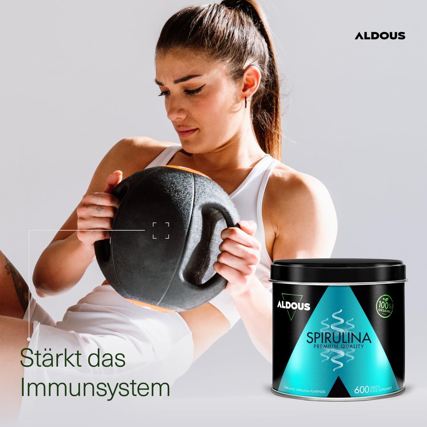 Femme s'entraînant avec un medecine ball, boîte Aldous Spirulina, renforce le système immunitaire, qualité premium.